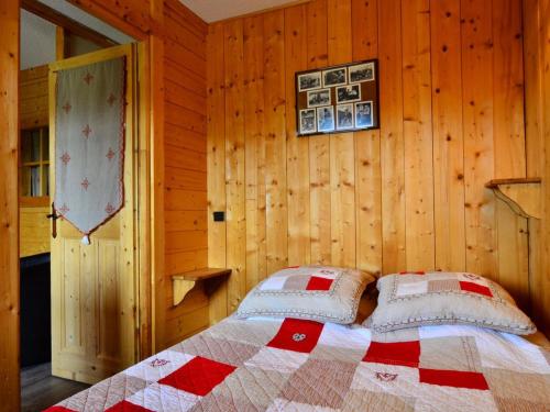 a bedroom with a bed in a wooden wall at Charmant appartement rénové 2/3 pièces pour 5 pers, proche pistes et commerces, parking gratuit - FR-1-329-29 in Bellentre