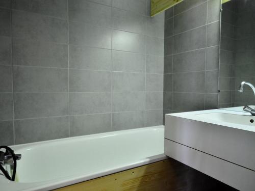a bathroom with a white tub and a sink at Charmant appartement rénové 2/3 pièces pour 5 pers, proche pistes et commerces, parking gratuit - FR-1-329-29 in Bellentre