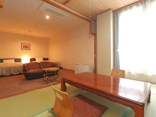 a living room with a dining table and a bedroom at Shugyoku no Yu Yakushido Onsen in Oshu