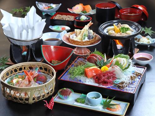 uma mesa com muitos pratos de comida em Shugyoku no Yu Yakushido Onsen em Oshu