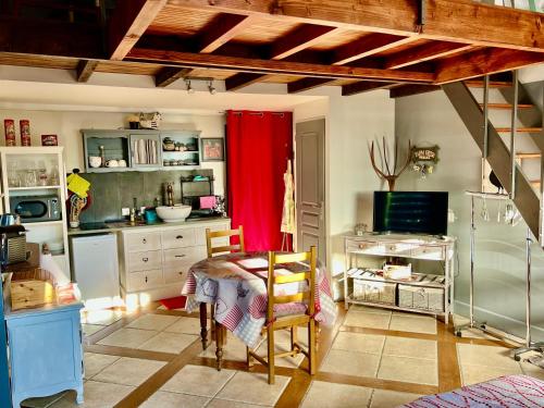 uma cozinha com mesa e cadeiras num quarto em Domaine Feuillet em Chanas