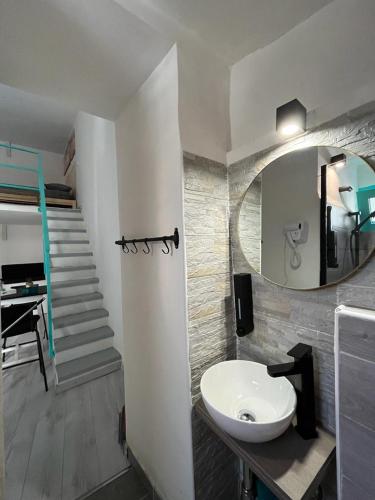 a bathroom with a sink and a mirror and a staircase at HomeSuite22 in Diamante