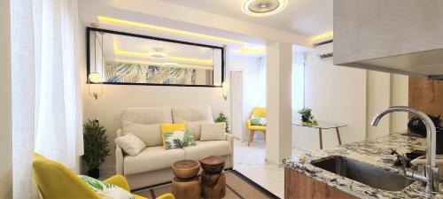 a living room with a white couch and a chair at ESTEPONA RADA BEACH ABC APARTMENTS & ESTUDIOS A in Estepona