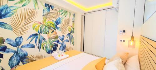 a room with a couch and a tropical wallpaper at ESTEPONA RADA BEACH ABC APARTMENTS & ESTUDIOS A in Estepona