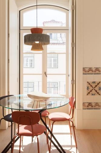 a dining room with a glass table and chairs at Nomad's Downtown Lisbon - Rua Augusta in Lisbon