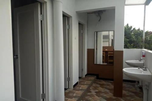 Bunul的住宿－Pondok Backpacker City Square Malang，浴室设有2个水槽和镜子