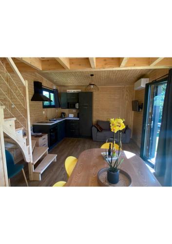 a kitchen and living room with a table in a room at La Cabane du Petit Moulin in Bressuire