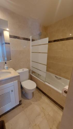 uma casa de banho com um WC, um lavatório e uma banheira em Lovely and luxury apartament in front of the beach em Los Alcázares