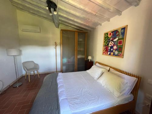 a bedroom with a bed with a painting on the wall at CasaMoira in Trequanda