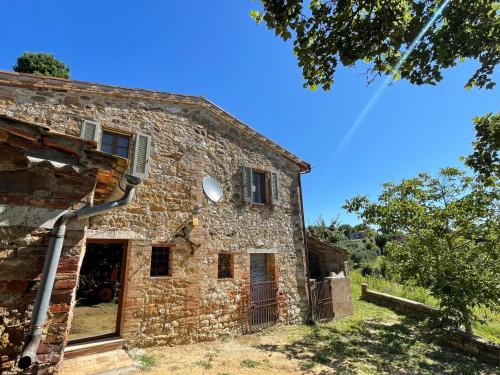 an old stone house with a gutter at CasaMoira in Trequanda