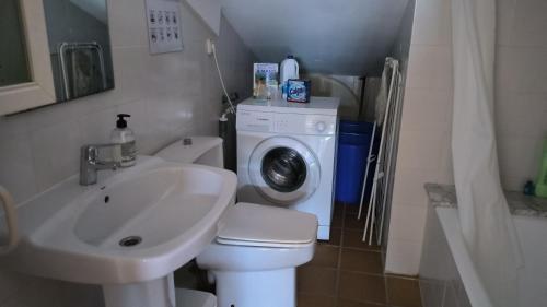a bathroom with a sink and a washing machine at Baywatch Penthouse in Altafulla