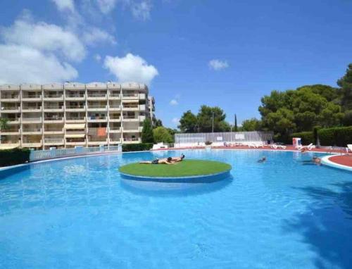 uma grande piscina com duas pessoas deitadas num círculo na água em Brisa Mar Apartamentos em Salou
