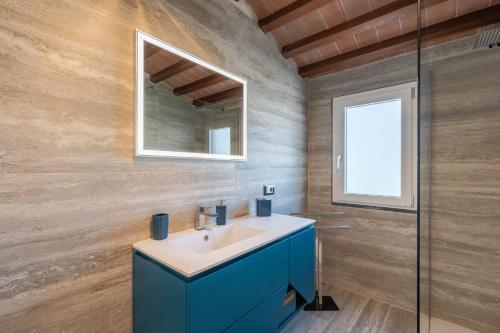 ein Badezimmer mit einem blauen Waschbecken und einem Spiegel in der Unterkunft Villetta Tiziana in Pisa