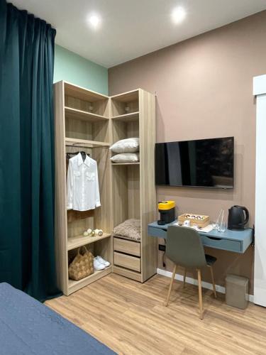 a bedroom with a bed and a desk and a television at Regina Elena Rooms in Pescara