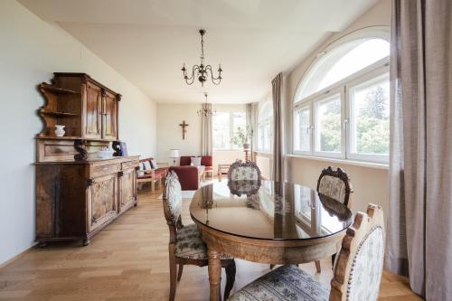 une salle à manger avec une table et des chaises en verre dans l'établissement Gästehaus Salvatorianerinnen, à Merano