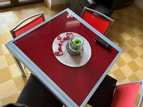 een rode tafel met een beker en een bord erop bij CASA EVA in Celano
