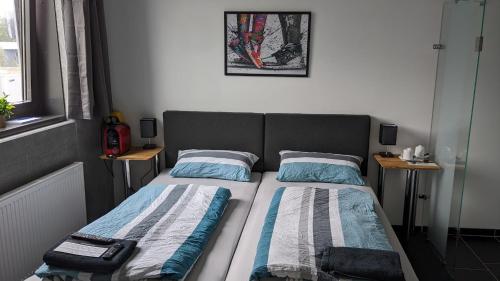 1 dormitorio con 1 cama con 2 almohadas en Business-Motel, Night-Checkin, Breakfast 2go, XL-Parking, free WiFi, en Heimsheim