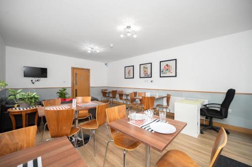 une salle à manger avec des tables et des chaises en bois dans l'établissement Flexistay Aparthotel Sutton, à Sutton