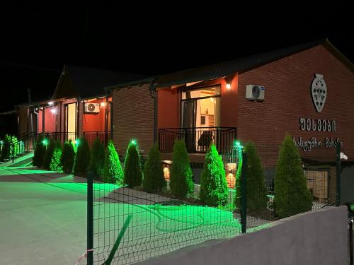 un edificio con luci verdi su un campo da tennis di Pesvebi Design Hotel and Cellar a Borjomi