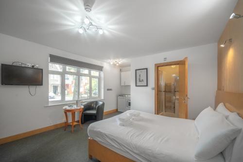 a bedroom with a bed and a desk and a television at Flexistay Aparthotel Sutton in Sutton