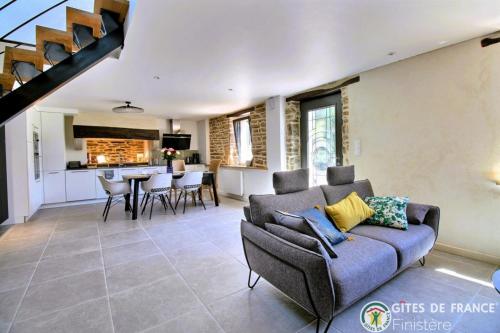 un salon avec un canapé et une cuisine dans l'établissement Le Penty du Petit-Kerauret, à Concarneau