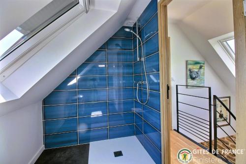 a bathroom with a blue tiled wall at Le Penty du Petit-Kerauret in Concarneau
