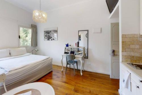 a white bedroom with a bed and a desk at Strategic 2BR Dizengoff Gordon in Tel Aviv
