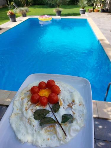 Un plato de comida en una mesa junto a una piscina. en Villa D Blagaj, en Blagaj