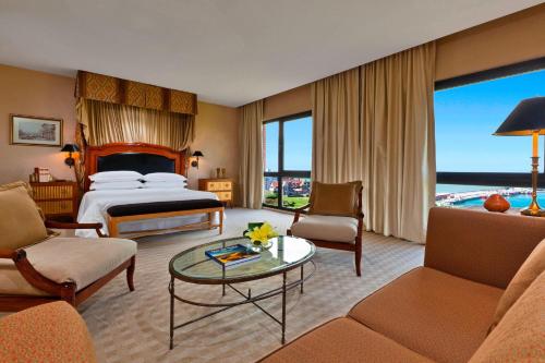 a hotel room with a bed and a living room at Sheraton Mar Del Plata Hotel in Mar del Plata