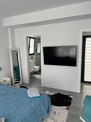 Un dormitorio con un televisor de pantalla plana y una cama. en Brilliant Villa, en Gran Alacant
