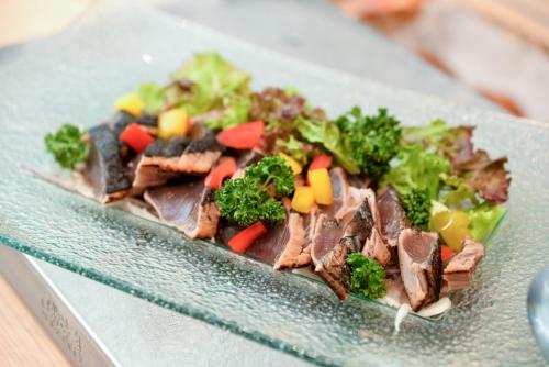 a plate of food with meat and vegetables on a table at Kagoshima Plaza Hotel Tenmonkan in Kagoshima