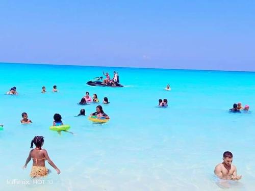 un grupo de personas en el agua en la playa en مرسى مطروح en Marsa Matruh