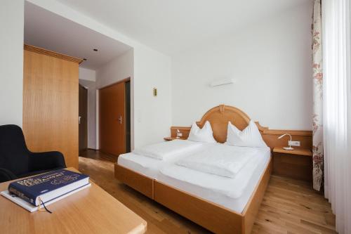 メラーノにあるGästehaus Salvatorianerinnenのベッドルーム1室(ベッド1台、デスク、椅子付)