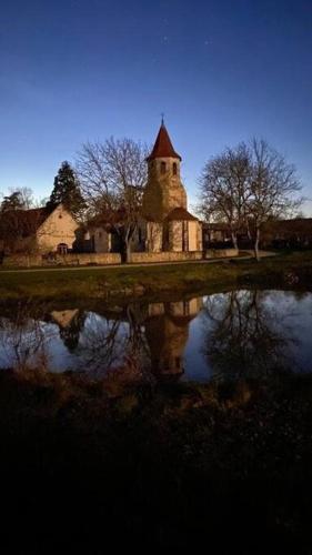 an old building with a reflection in a body of water at Le Bouchat : Maisonnette au calme pour 2 +1 guest in Cesset