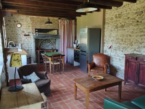 a kitchen and a living room with a couch and a table at Le Bouchat : Maisonnette au calme pour 2 +1 guest in Cesset