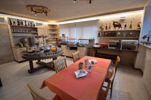 a kitchen with a table and chairs and a kitchen with a counter at Hotel Cime D'Oro in Madonna di Campiglio