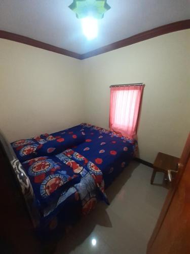 ein kleines Schlafzimmer mit einem Bett und einem Fenster in der Unterkunft Widodaren Homestay in Probolinggo