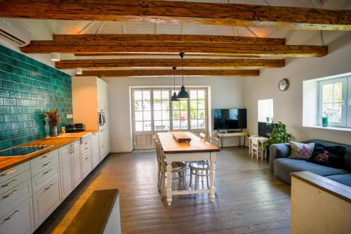 a kitchen and living room with a table and a couch at matyóróza vendégház in Tard