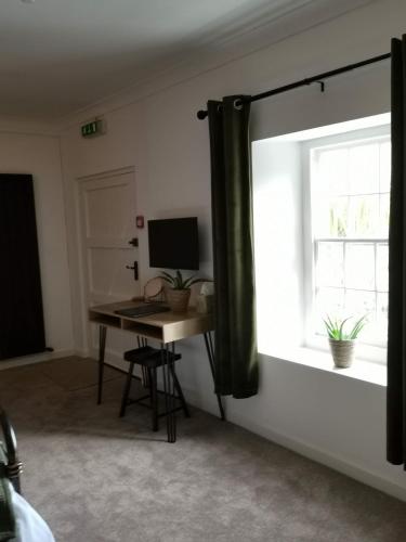 a room with a desk and a window with a computer at The Wolfe Inn Wolfscastle in Haverfordwest