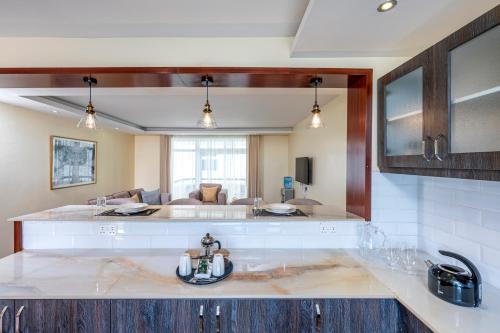 a kitchen with a sink and a living room at Roma Court Serviced Apartments in Nairobi