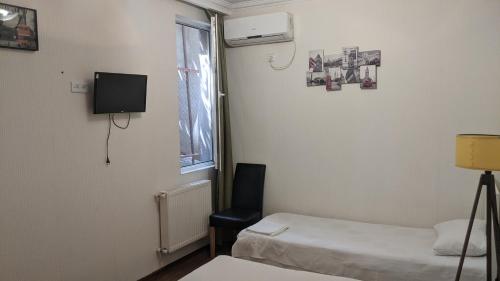 a room with two beds and a chair and a window at Old Capital in Mtskheta