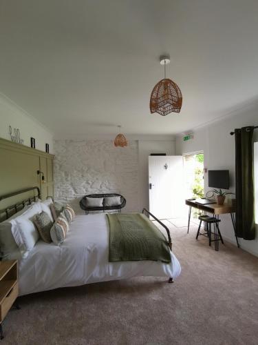 a bedroom with a large white bed and a desk at The Wolfe Inn Wolfscastle in Haverfordwest