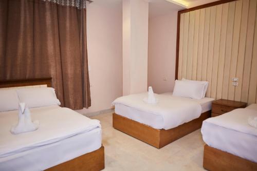 a hotel room with two beds and a window at Grand Pyramid View Hotel in Cairo