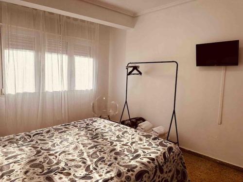 1 dormitorio con 1 cama con manta blanca y negra en Casa del Kun. San Juan de L`Arena, en San Juan de la Arena