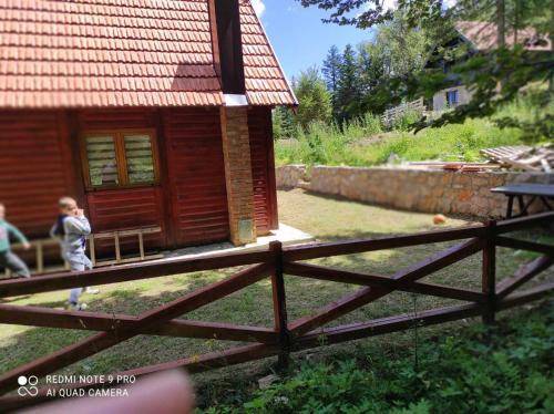 a small wooden cabin with a fence in front of it at BRVNARA MILA in Zaovine