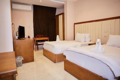 a hotel room with two beds and a television at Grand Pyramid View Hotel in Cairo