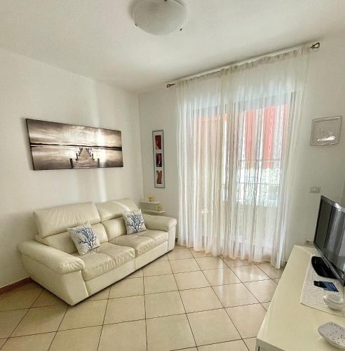 uma sala de estar com um sofá e uma televisão em Sea la Vie em Alghero