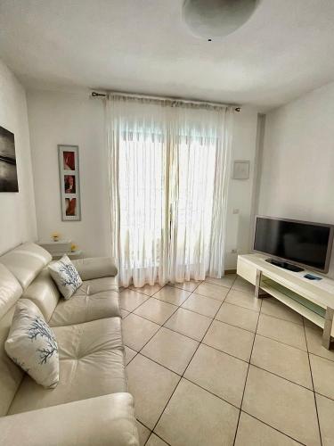 a living room with a white couch and a television at Sea la Vie in Alghero