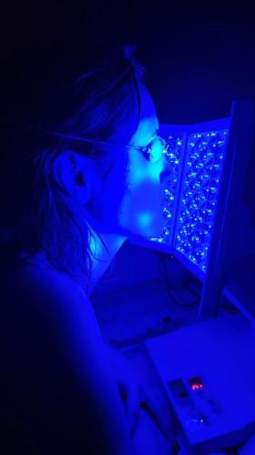 a girl is sitting in the dark with a laptop at Apartmánový dom Harmónia in Modra
