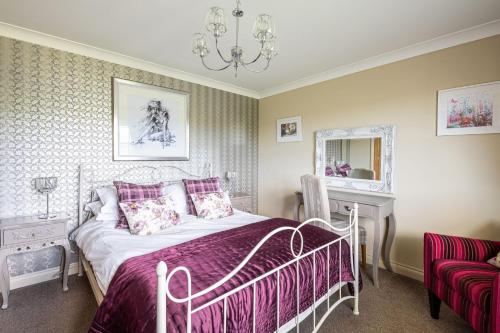 1 dormitorio con cama y lámpara de araña en Primrose Cottage en Whitby